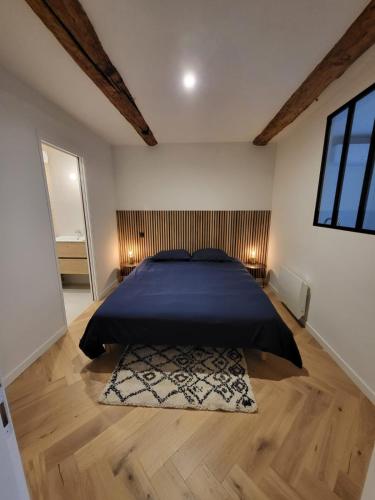 - une chambre avec un lit doté d'un couvre-lit bleu et d'un tapis dans l'établissement Appartement des Augustins, à Aix-en-Provence