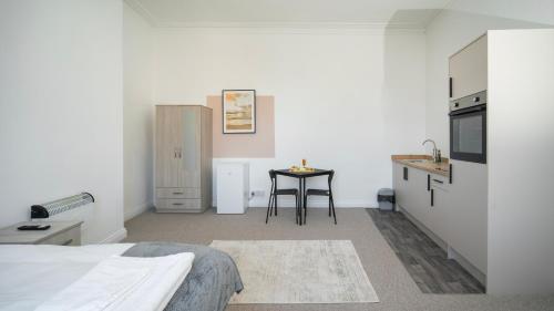 a room with a bed and a kitchen with a table at YSS The Church 1 Coatham in Redcar