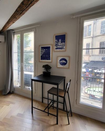 une table et une chaise dans une chambre avec fenêtre dans l'établissement Appartement des Augustins, à Aix-en-Provence