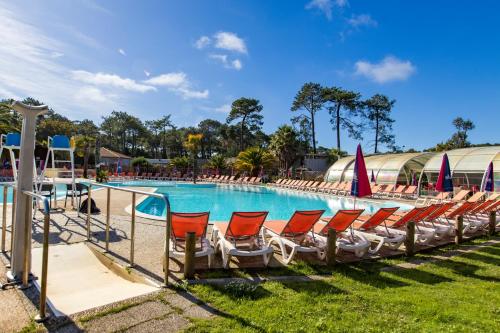 une rangée de chaises assises à côté d'une piscine dans l'établissement Mobil home Amira 42m2, à Lège-Cap-Ferret