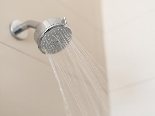 a shower head with water coming out of it at Rieks van der Walt Self-Catering Apartment in Windhoek
