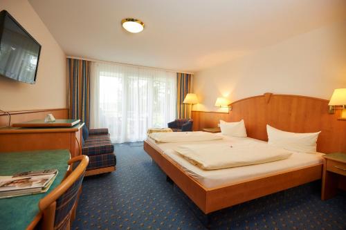 a hotel room with a bed and a television at Flair Hotel Landgasthof Roger in Löwenstein