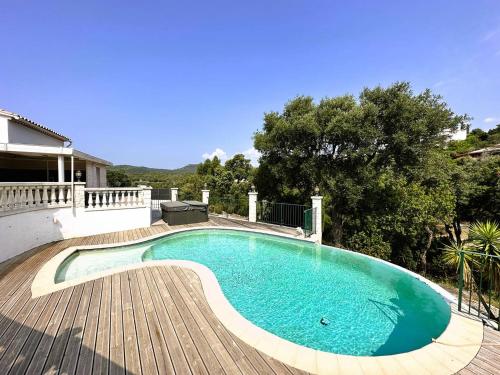 - une piscine sur une terrasse en bois à côté d'une maison dans l'établissement Villa Cigalou pour 8 personnes avec piscine chauffée et petite vue mer au domaine de Valcros à La Londe les Maures, à La Londe-les-Maures