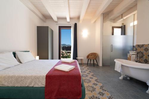 a bedroom with a tub and a bed and a bath tub at Relais Tenuta Santori in Cossignano