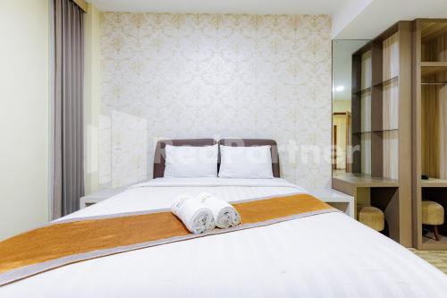 a bedroom with a white bed with towels on it at De Malang Sweet Homestay Syariah Mitra RedDoorz in Malang