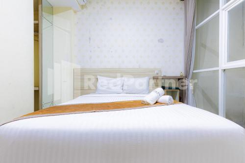 a white bed in a room with a window at De Malang Sweet Homestay Syariah Mitra RedDoorz in Malang