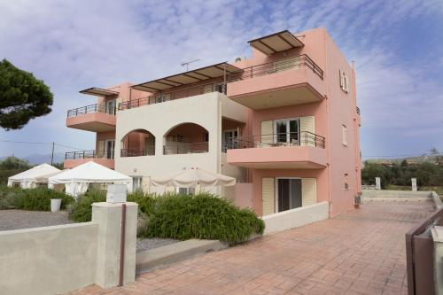 a pink building with umbrellas in front of it at Casa di Terra in Gythio