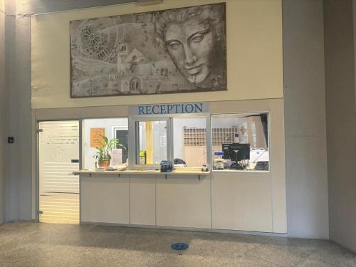 a reception area in a building with a painting on the wall at Serafico Guesthouse in Rome