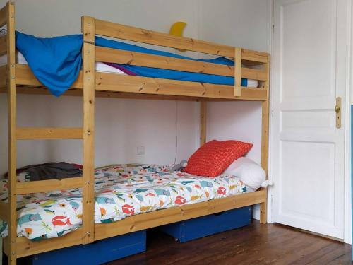 - un lit superposé avec un oreiller rouge sur la couchette inférieure dans l'établissement Paroisse 2 - CI - Versailles Le Hoche, à Versailles