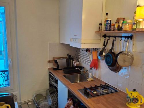 une cuisine avec un évier et un plan de travail dans l'établissement Paroisse 2 - CI - Versailles Le Hoche, à Versailles