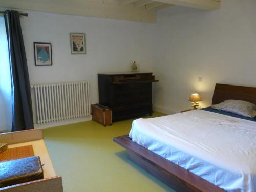 a bedroom with a bed and a dresser at Ferme de la Rose in Rosans