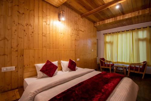 a bedroom with a large bed in a wooden room at Crystal Mountain Jibhi in Jibhi