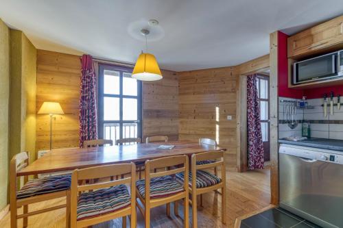 a kitchen and dining room with a wooden table and chairs at Chalet le Regain in Villard-Reculas