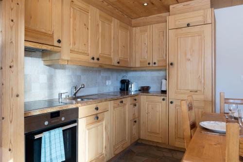 a kitchen with wooden cabinets and a sink and a table at Claire Joie in Verbier