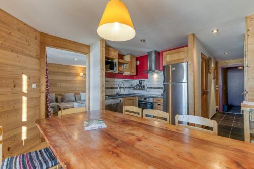 a kitchen and dining room with a wooden table at Chalet le Regain in Villard-Reculas