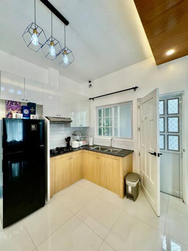 a kitchen with a black refrigerator and a sink at Casa Leonardo-Bel Air 4 in Santa Rosa