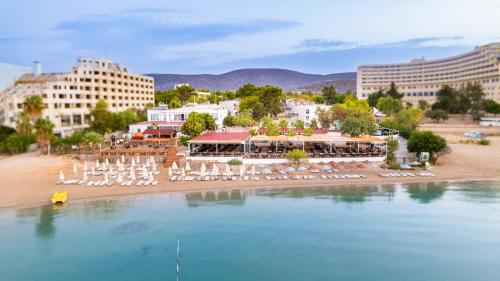 a view of a beach with chairs and a resort at Maya World Didyma Hotel in Didim