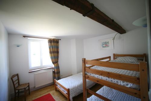 Un dormitorio con una litera y una ventana. en Les gîtes de la Font, en Usson-du-Poitou