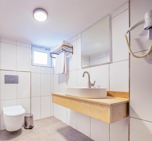 a bathroom with a sink and a toilet at Maya World Didyma Hotel in Didim
