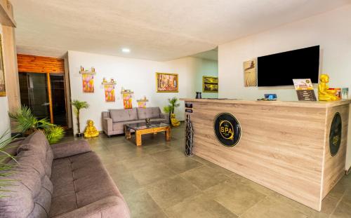 a living room with a couch and a flat screen tv at Maya World Didyma Hotel in Didim