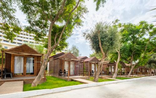 a row of cottages in a city with trees at Maya World Didyma Hotel in Didim
