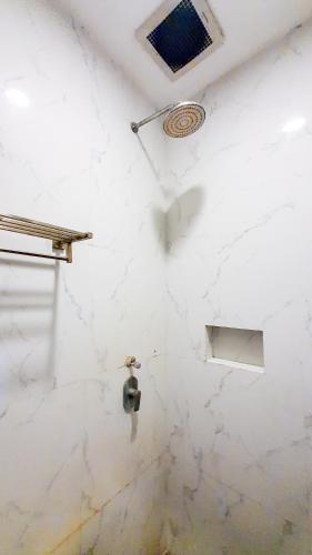 a bathroom with a white marble wall with a window at La'Rissa Residence by ARBA in Karawang