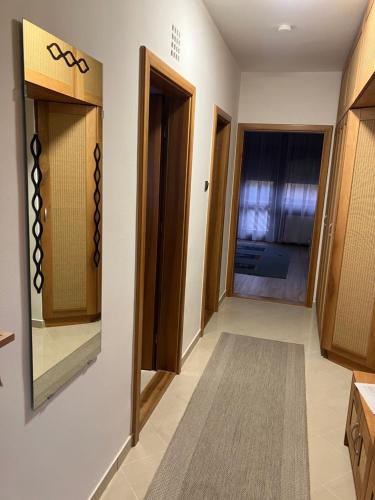 a hallway with wooden cabinets and a door at JAMA-KECÓ Apartman in Bonyhád