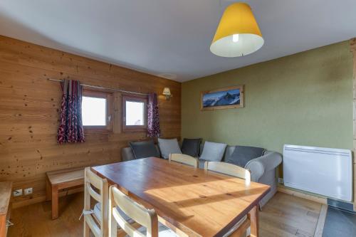 a living room with a wooden table and a dining room at Chalet le Regain in Villard-Reculas