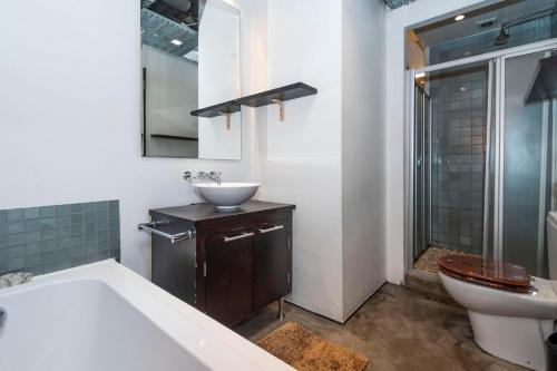 une salle de bain avec une baignoire, un lavabo et des toilettes dans l'établissement Manhattan-style 2-bedroom apartment, au Cap