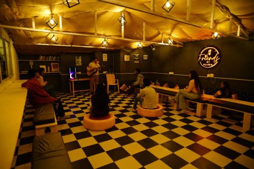 a group of people sitting on a checkered floor in a restaurant at Friends by Alizeh Bhagsunag McLeodganj in McLeod Ganj