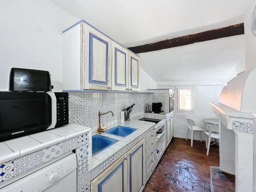 une cuisine avec un évier et un micro-ondes dans l'établissement App'Art Vieil Antibes, à Antibes