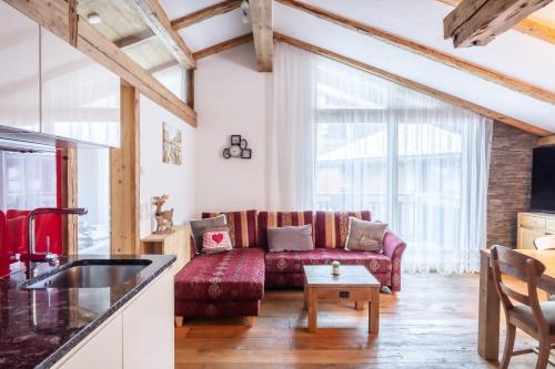 a living room with a red couch and a table at URALP Royal in Brand