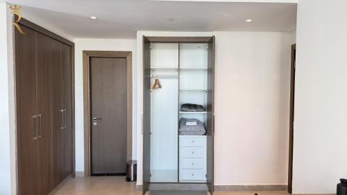 a room with a closet with white walls and a door at Luxury 2BR Living in Al Rahah - Elegant Stay Near Al Raha Beach & Marina in Abu Dhabi