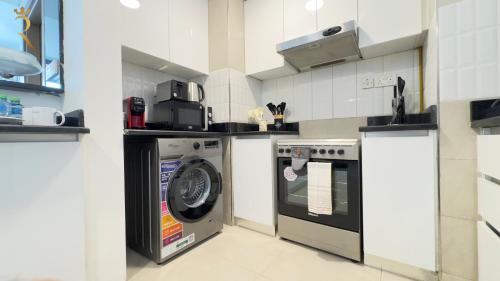 a kitchen with a washing machine and a washer at Luxury 2BR Living in Al Rahah - Elegant Stay Near Al Raha Beach & Marina in Abu Dhabi