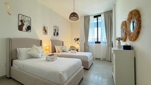 a living room with two beds and a couch at Luxury 2BR Living in Al Rahah - Elegant Stay Near Al Raha Beach & Marina in Abu Dhabi