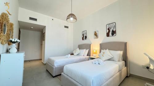 a hotel room with two beds and a couch at Luxury 2BR Living in Al Rahah - Elegant Stay Near Al Raha Beach & Marina in Abu Dhabi