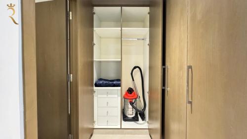 a walk in closet with a hose in it at Luxury 2BR Living in Al Rahah - Elegant Stay Near Al Raha Beach & Marina in Abu Dhabi
