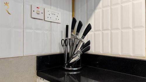 a kitchen counter with a vase filled with kitchen utensils at Luxury 2BR Living in Al Rahah - Elegant Stay Near Al Raha Beach & Marina in Abu Dhabi