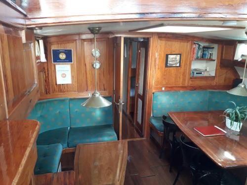 a dining car of a train with a table and chairs at Tjalkjacht Pelikaan Hoorn in Hoorn