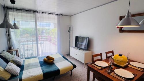 une chambre avec un lit, une table et une télévision dans l'établissement Studio dans quartier calme - climatisation - terrasse - parking - à 900m des plages et 400m des commerces, à La Grande Motte