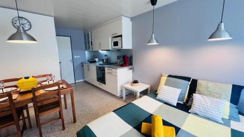 un salon avec une cuisine et une salle à manger dans l'établissement Studio dans quartier calme - climatisation - terrasse - parking - à 900m des plages et 400m des commerces, à La Grande Motte