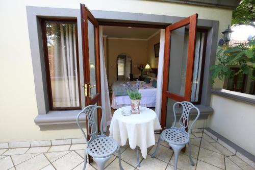 a table with two chairs and a vase of flowers on a balcony at Villa Lugano Guesthouse in Johannesburg