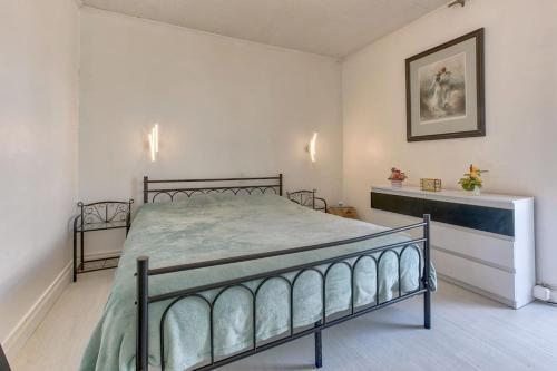 une chambre avec un lit dans une pièce blanche dans l'établissement Le Sunset, à Biscarrosse