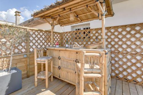d'une terrasse avec un bar en bois et des tabourets. dans l'établissement Le Sunset, à Biscarrosse