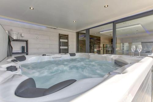 Cette chambre dispose d'une grande baignoire et de fenêtres. dans l'établissement Le Sunset, à Biscarrosse