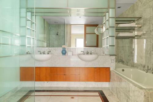 a bathroom with two sinks and a tub and a mirror at Stylish & Cozy 4BR Retreat with FREE Parking in Melbourne