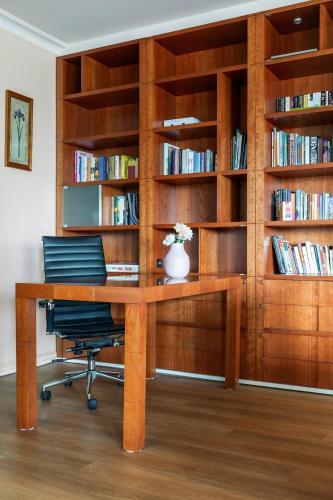 an office with a wooden desk and book shelves at Stylish & Cozy 4BR Retreat with FREE Parking in Melbourne