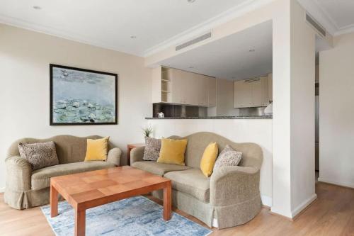 a living room with two couches and a table at Stylish & Cozy 4BR Retreat with FREE Parking in Melbourne