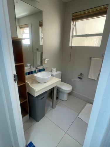 Un baño con lavabo, inodoro y espejo. en C9 Salamander, en Durban