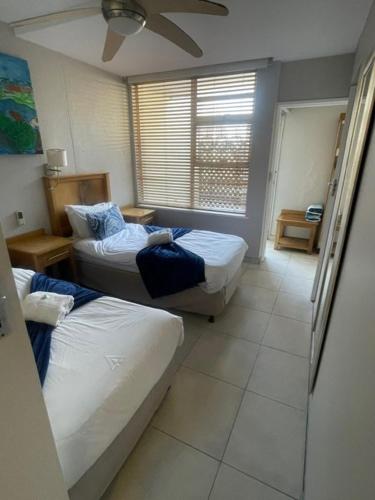 Una pequeña habitación con dos camas y una ventana. en C9 Salamander, en Durban